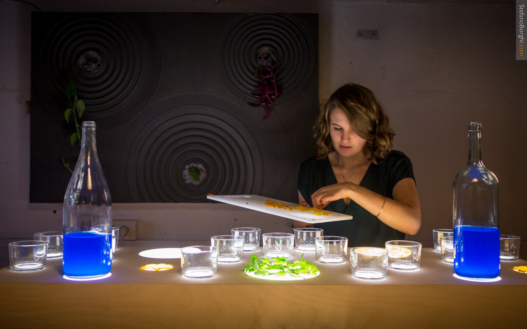 A cocktail evening in the Volumes food lab, Paris: glasses and blue bottles on a luminous table